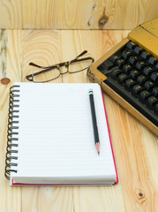 pencil and notebook on wood background