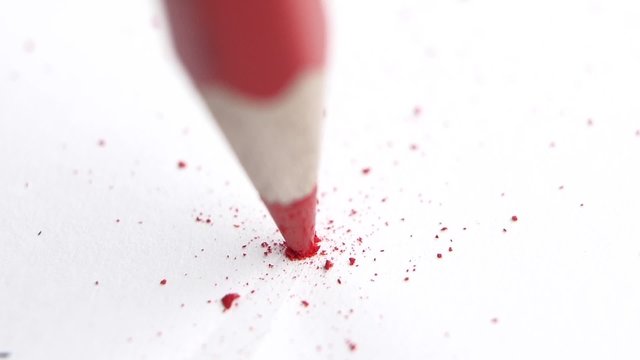 Broken head of sharp red pencil on a white, slow motion