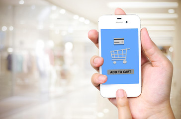 Hand holding smart phone with add to cart words on screen