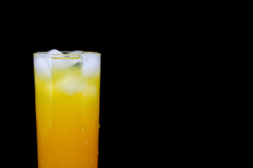glass of fresh orange juice with ice isolated on a black background