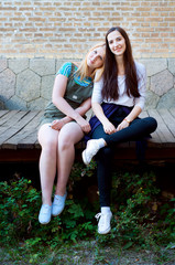 Two friends sitting on a bridge