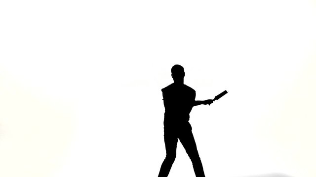 silhouette of barman showing tricks with a bottle 