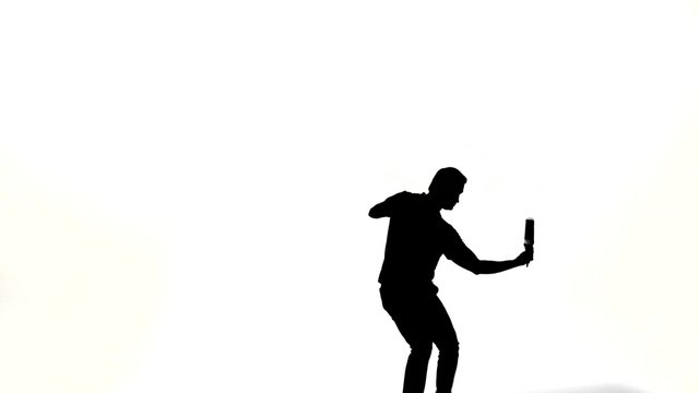 silhouette of barman man showing tricks with a bottle 