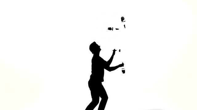 silhouette of barman man showing tricks with a bottle 