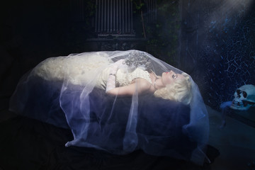Sleeping Beauty. Beautiful lifeless bride in white dress lying o