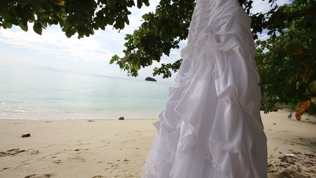 white wedding dress hangs on island