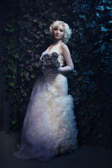 Obraz na płótnie Canvas Beautiful gothic woman in white dress and roses