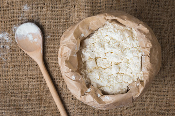 Whole flour and wooden spoon, top view