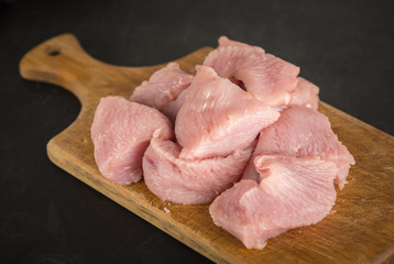 Raw fresh minced turkey meat on a wooden cutting board