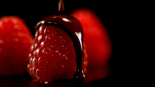 Melted chocolate pouring over raspberries
