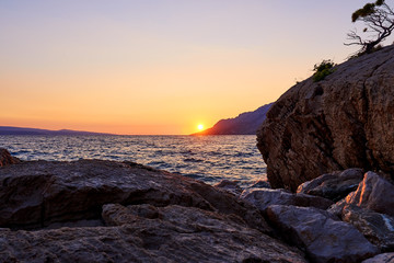 Rock island at golden sunset in Brela, Croatia