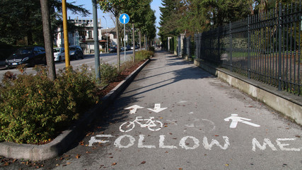 Follow me scritto sulla pista ciclabile