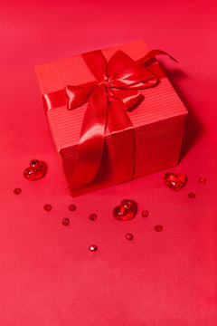 Gift box with bow and hearts on the red background