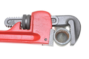 Red plumbers pipe wrench and plumbing component isolated on white background
