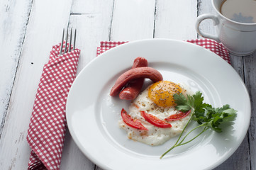 scrambled eggs on a plate with pieces of tomato and sausage