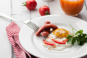 scrambled eggs on a plate with pieces of tomato and sausage