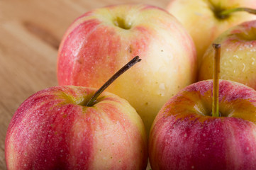 wet fuji apple on wood chop block and on wood table