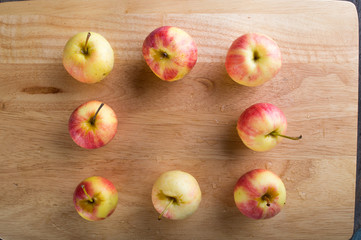 wet fuji apple on wood chop block and on wood table