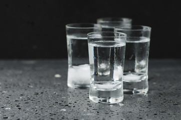 A glass of vodka on the black table