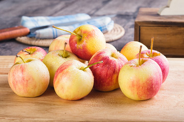 wet fuji apple on wood chop block and on wood table