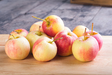 wet fuji apple on wood chop block and on wood table