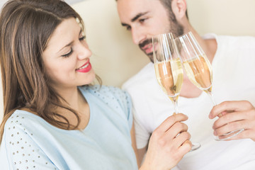 Happy couple making a toast on the bed