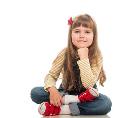 cute little girl wearing jeans overall sitting on the floor and