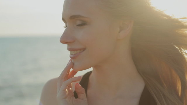 Beautiful green-eyed blonde with long hair in golden rays of the