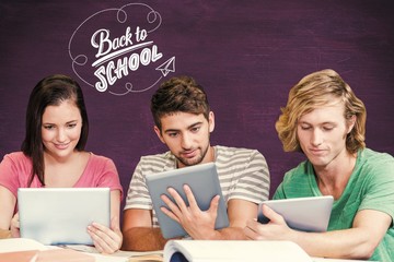 College students using digital tablets in library