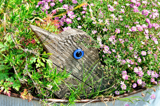 Holzvogel im Blumenbett