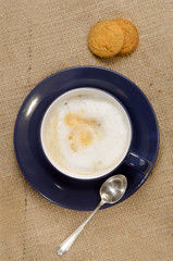 coffee with milk foam and biscuit