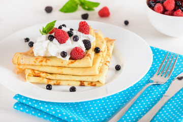 Delicious sweet crepes decorated air-cream and ripe berries