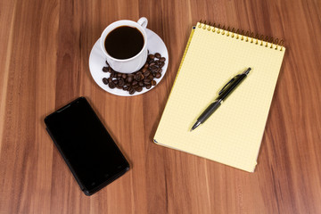 Cup of coffee,phone and notebook