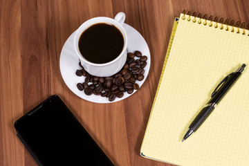 Cup of coffee,phone and notebook