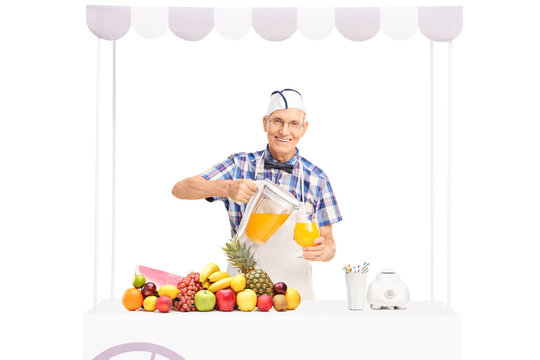 Senior soda jerk pouring orange juice into a glass
