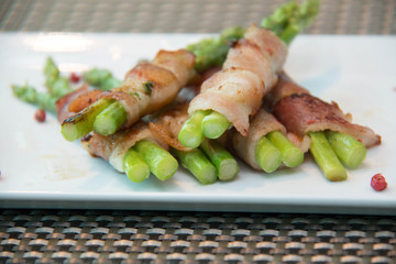 Asparagus wrapped in bacon with italian sauce