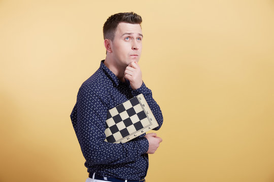 the young man with a chessboard on a yellow background