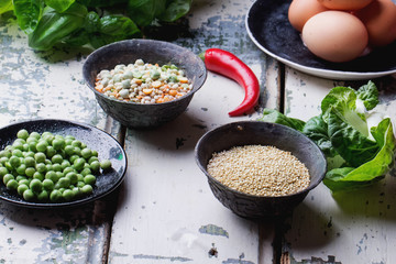 Quinoa Burger ingredients: quinoa, mangold, dry grain mix, chili pepper, eggs green peas basil on white rustic board