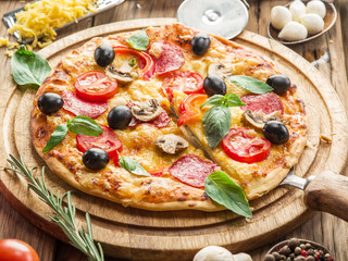 Pizza with mushrooms, salami and tomatoes.