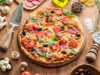 Pizza with mushrooms, salami and tomatoes.