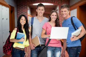 Smiling group of students holding a laptop 