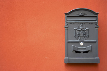 grey mailbox on a red wall