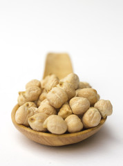 Chick peas on wooden spoon isolated on white background