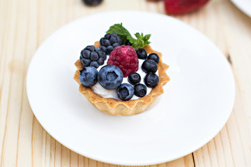 Tart  with Fresh berries - dessert on wooden table close up