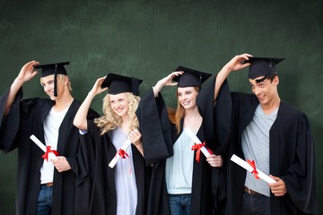 Obraz premium Composite image of group of teenagers celebrating after graduation