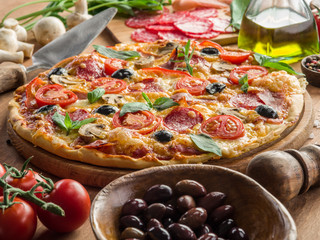 Pizza with mushrooms, salami and tomatoes.