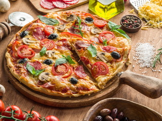 Pizza with mushrooms, salami and tomatoes.