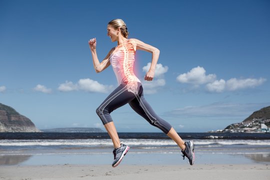 Highlighted back bones of jogging woman on beach