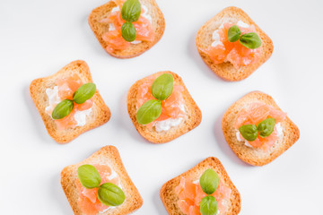 Top view on canapes with smoked salmon and cottage cheese.