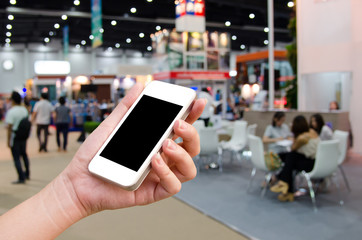 woman hand holding the phone tablet on blur event background